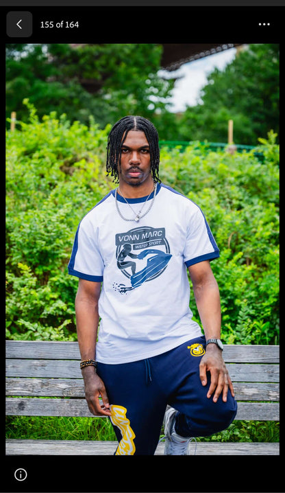 VONN MARC blue Jet Ski T- Shirts model posing outdoors on a bench with greenery in the background.